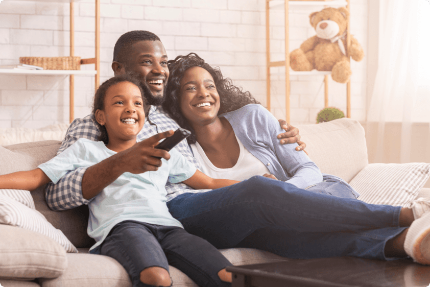 Smiling family on couch watching tv