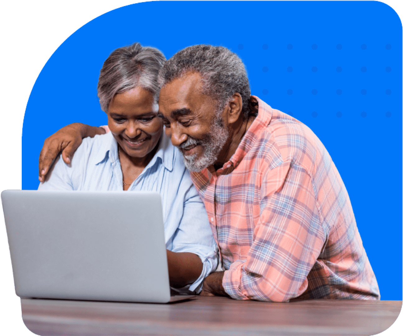 Smiling senior couple looking down at laptop