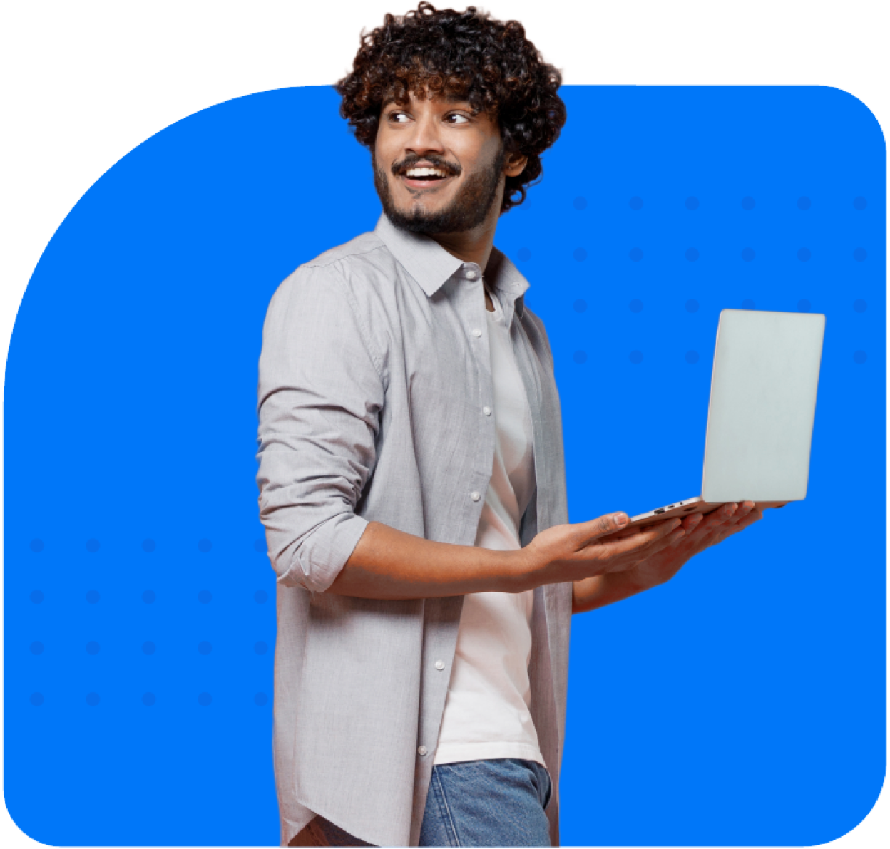 Smiling man standing up with laptop in his hands, turning his head behind with a surprised expression